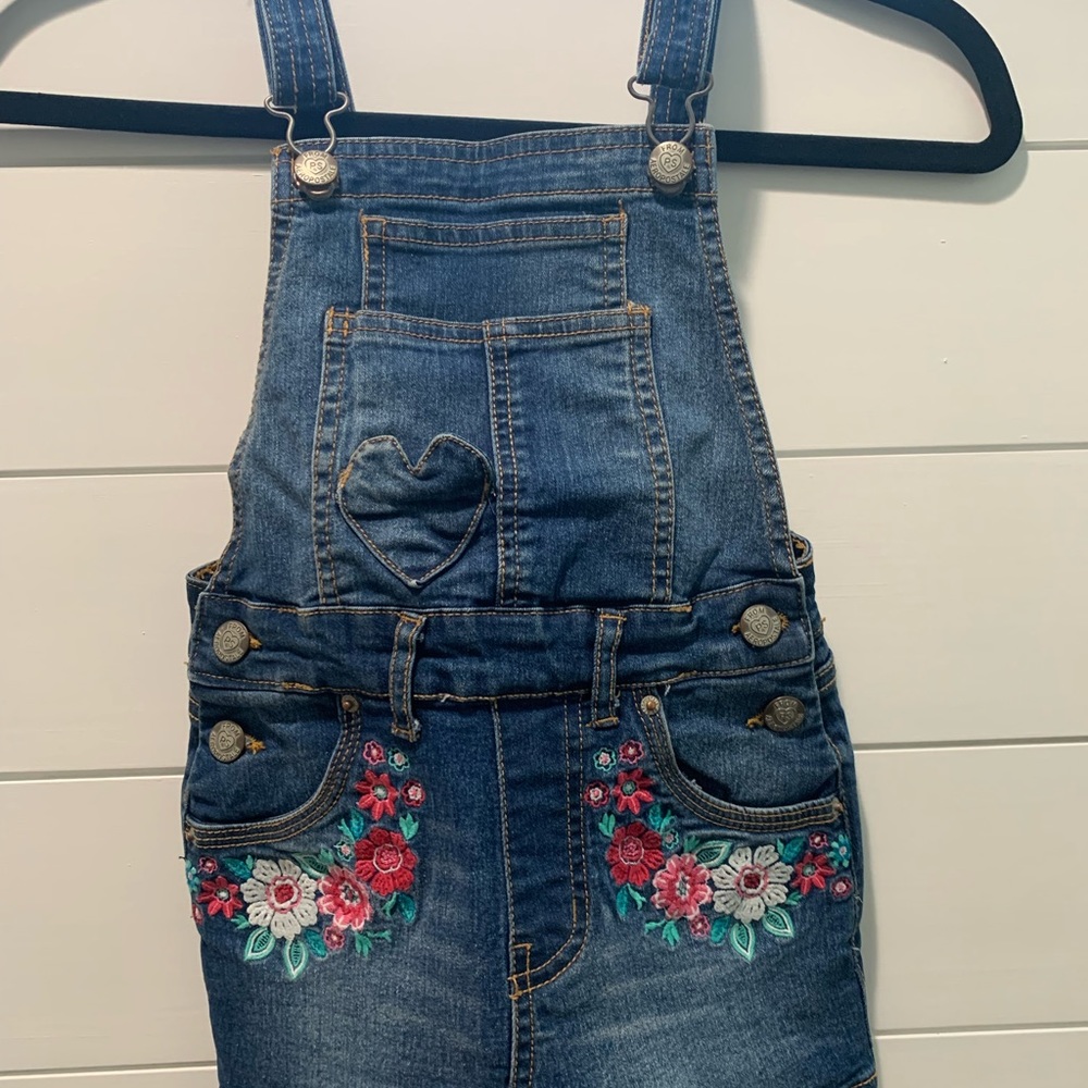 Skirt overalls with embroidered flowers.